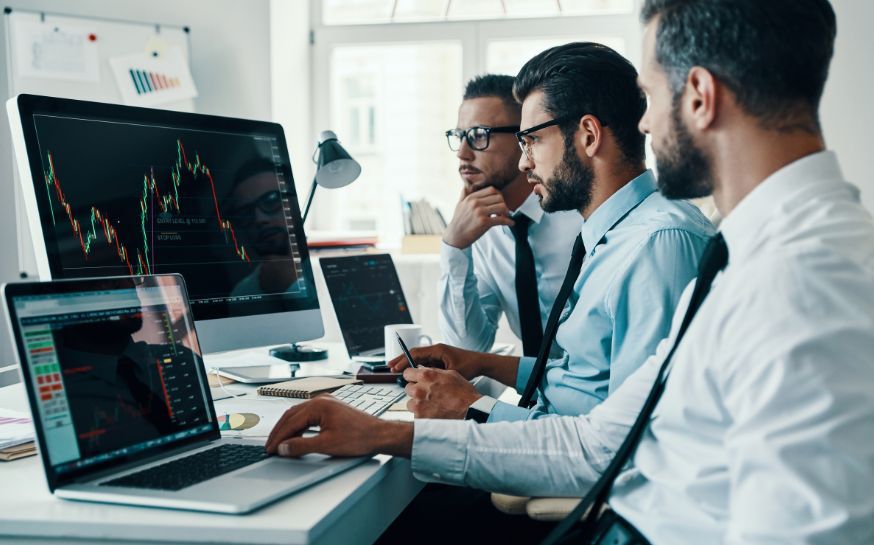 Three investors looking at the computer.